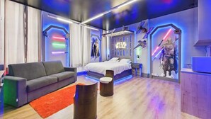 A Star Wars-themed bedroom with a bed, a gray couch, and Star Wars decorations. - Jol Tourisme (Troyes)