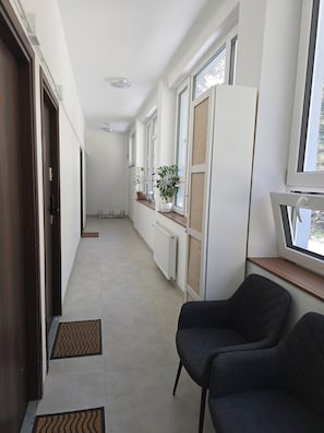 En hall med ett element, krukväxter och en stol.