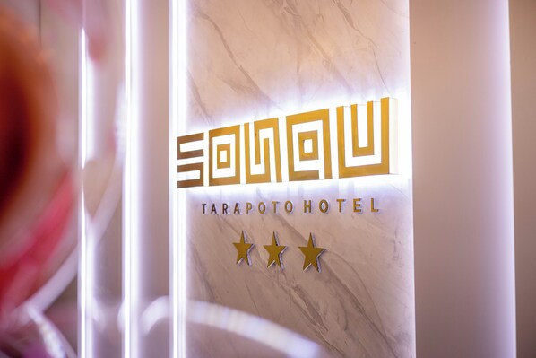 A sign with the name "Tarapoto Hotel" and three gold stars.