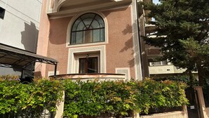 A building with a large arched window and a balcony. - Hillside Garden (Skopje)