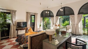 A modern hotel room with a bed, TV, and a glass dining table. - Viraam Estate by RÊVE/Infinity heated pool with caretaker/Chef (Assagao)