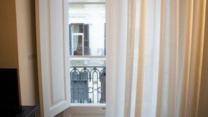 Une porte donnant sur un balcon agrémenté de balustrades en métal.