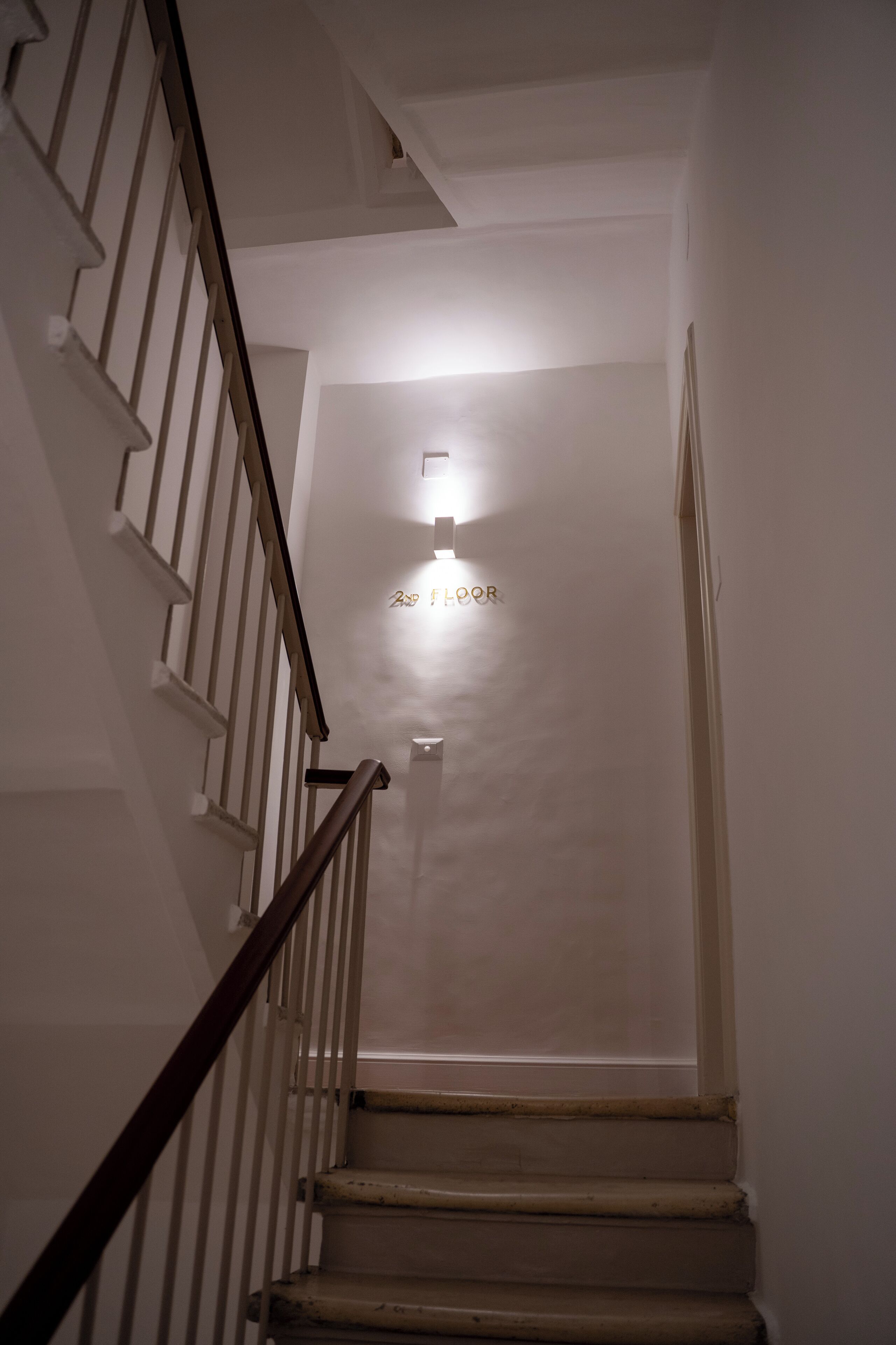 A staircase leading to the 2nd floor with a light fixture above.