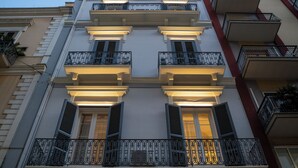 Un immeuble à plusieurs étages doté de balcons, de grandes fenêtres et d’un style architectural classique.