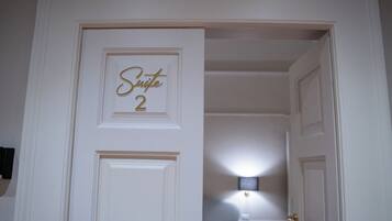 A white door with a sign that reads "Suite 2" in gold lettering.