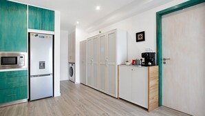 Une cuisine moderne équipée d’un four à micro-ondes, d’un réfrigérateur et d’un lave-linge.