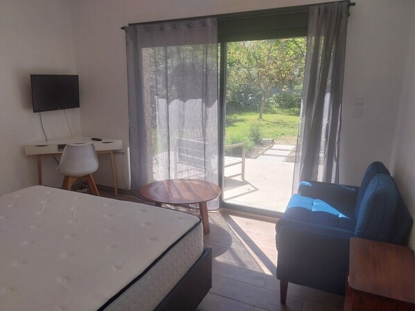 A hotel room with a bed, a desk, a chair, a small round table, and a sofa. - Villa with a garden, 7 km from the beaches (Elne)