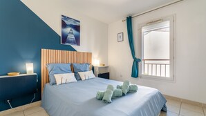 A bedroom with a bed, a bedside table, a nightstand, a window with curtains, and a wall-mounted picture. - Villa 'Chez Marco' with Private Terrace, Wi-Fi, and Air Conditioning (Saint-Rémy-de-Provence)