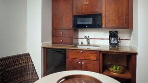 A compact kitchen with wooden cabinets, a microwave, a coffee maker, and a sink. - Beautiful Ocean View Studio at Marriott Kauai Beach Club (Knoxville)