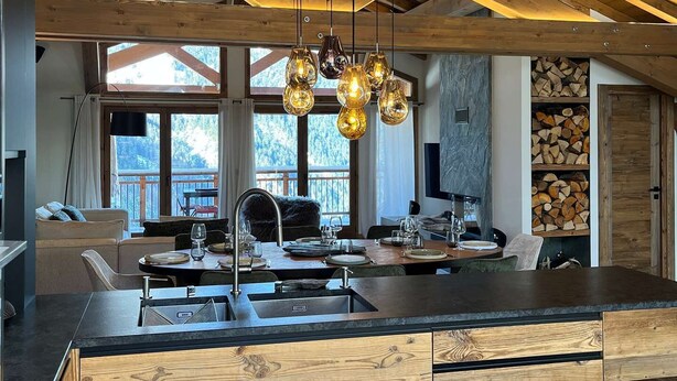A modern kitchen with a wooden ceiling, large windows, and a central island with a sink. - T4 spacieux avec cheminée (Peisey-Nancroix)