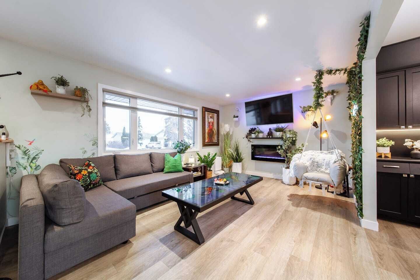 A modern living room with a sofa, coffee table, and a TV mounted on the wall.