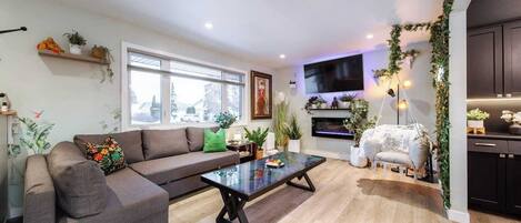A modern living room with a sofa, coffee table, and a TV mounted on the wall.