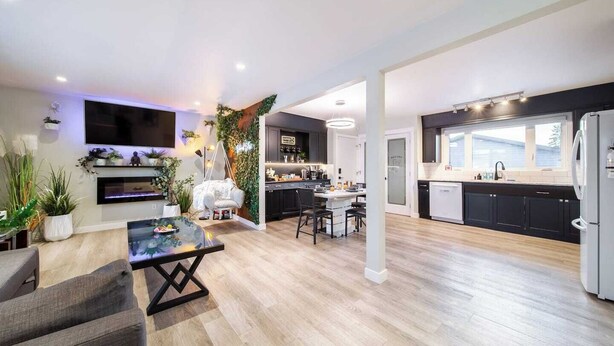A modern kitchen with dark cabinets, a white refrigerator, and a large window. - Relax, recharge, and play. Just 15 mins from Downtown Edmonton (Edmonton)