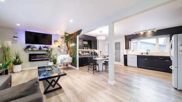 A modern kitchen with dark cabinets, a white refrigerator, and a large window.