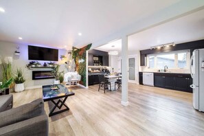 A modern kitchen with dark cabinets, a white refrigerator, and a large window. - Relax, recharge, and play. Just 15 mins from Downtown Edmonton (Edmonton)