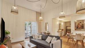 Een moderne woonkamer met een bank, salontafel en eethoek.