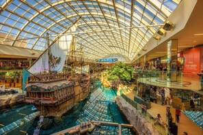 Un vaste atrium intérieur doté d’un toit de verre, où l’on peut admirer une épave et une fontaine centrale.