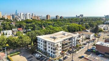 A multi-story building with a flat roof, surrounded by a parking lot and greenery.