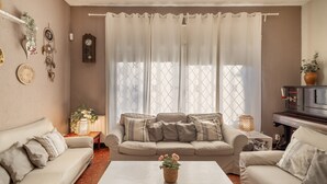A living room with a sofa set, a coffee table, a fireplace, and decorative items on the walls. - Holiday Home 'Tordera Village' with Mountain View, Private Pool and Wi-Fi (Tordera)
