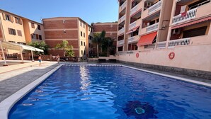Une piscine à l’eau d’un bleu limpide, entourée d’une terrasse carrelée.