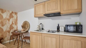 A modern kitchen with wooden cabinets, a white countertop, a coffee maker, a toaster, and a microwave.