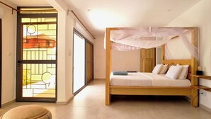 A bedroom with a wooden bed, a canopy, a sliding glass door, and a view of the outside. - Independent suite in luxury guest house (Ngaparou)