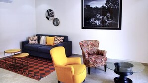 A living room with a sofa, two armchairs, a coffee table, and a patterned rug. - Independent suite in luxury guest house (Ngaparou)