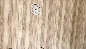 A dining table with a white tablecloth, four chairs, and a clock on the wall. - Vacations on a horse farm / vacation in the country, between Bremerhaven, HH and HB (Gnarrenburg)