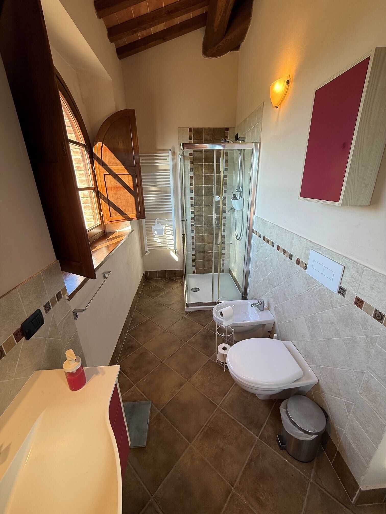 A bathroom with a shower, toilet, and sink.