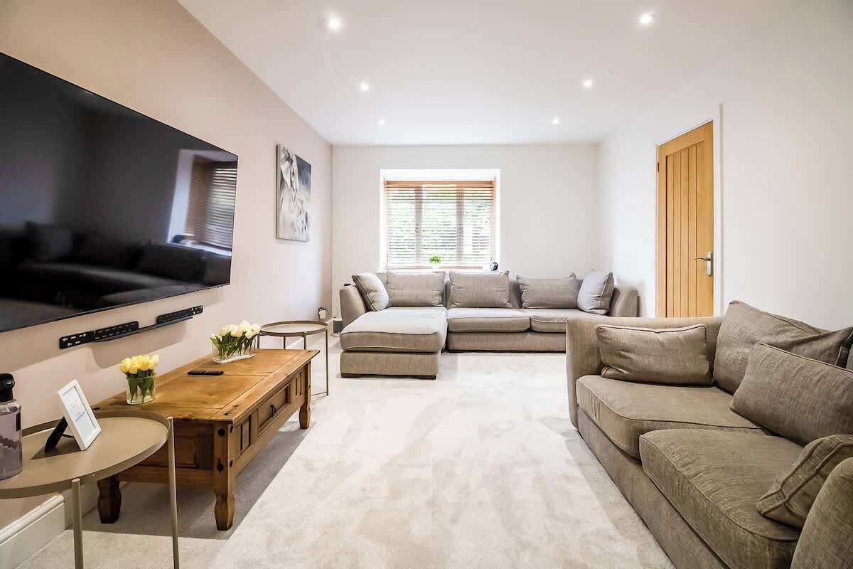 “Spacious living room with comfy sofas and a TV — perfect for family time, movie nights, or bonding with friends.”