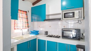 Une cuisine avec des meubles de couleur bleue, un four à micro-ondes, un grille-pain et un évier.