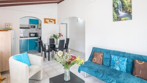 Un salon moderne comprenant un canapé, une table basse et un coin repas avec des chaises et une table.