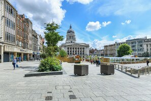 A public square with a prominent building featuring a dome, surrounded by historic buildings and a clear sky.