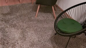 A room with two chairs, a small table, and a green accent wall.