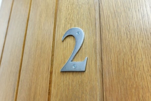A metallic number 2 sign on a wooden surface.