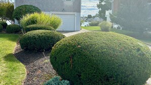 A two-story house with a garage, surrounded by well-maintained lawns and hedges. - Serene Waterfront 3-BR house with Loft, 1 mile walk to Charlestown beach (Charlestown)