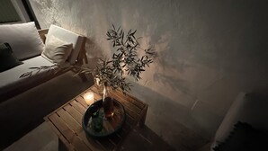 Um cantinho aconchegante com uma mesa de madeira, uma vela e um vaso com planta.