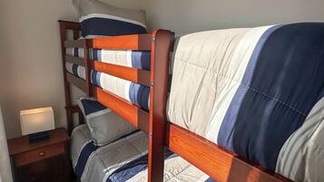 A bunk bed with a wooden frame and striped bedding.