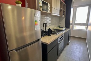 Basic Apartment | Private kitchen | Full-sized fridge, microwave, stovetop, cookware/dishes/utensils - Laguna Oriente by Andes+ (Concepción)