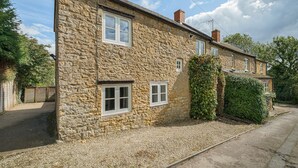 A stone house with two visible windows, a chimney, and a gravel driveway. - Pass the Keys | Cotswold Country Style Living | Chipping Norton (Chipping Norton)