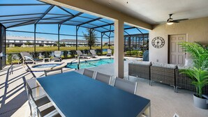 A covered outdoor area with a pool, lounge chairs, and a table. - Solterra- LakeView - Private Pool & Spa  (Davenport)