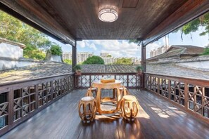 A wooden deck with a round table and stools, surrounded by a wooden railing. - Juchunyuan Hotel (Fuzhou Sanfang Qixiang) (Fuzhou)