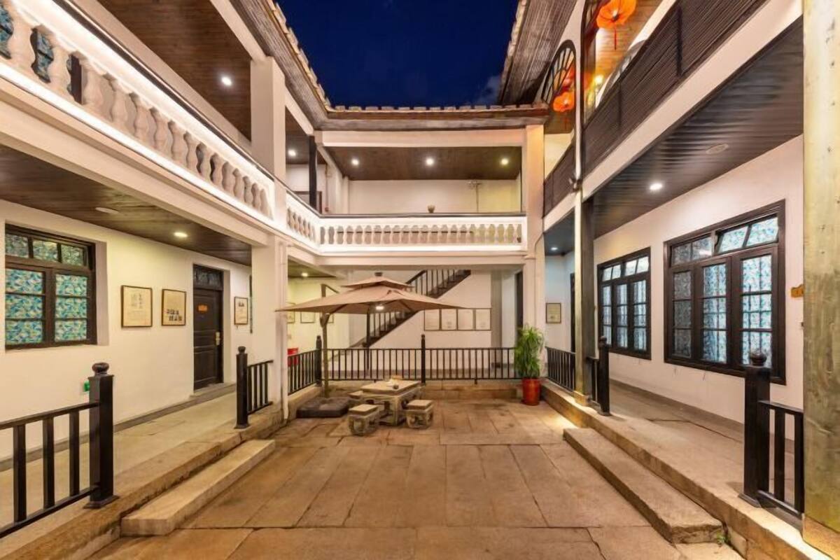 Un patio con una escalera, asientos exteriores y una planta en maceta.