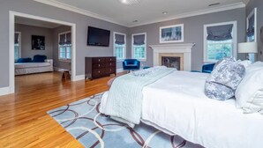 A bedroom with a large bed, a dresser, a chair, and a fireplace. - Luxury 5BR retreat w/3rd floor sleeps 26 adults; 1 mile to town; 1 month min (Ridgefield)