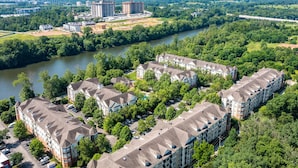 Un ensemble résidentiel comprenant plusieurs immeubles d’appartements, une rivière et des espaces verts environnants.