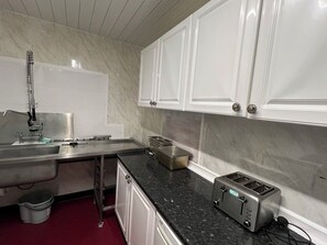 Frigorífico grande, placa de cocina y utensilios de cocina