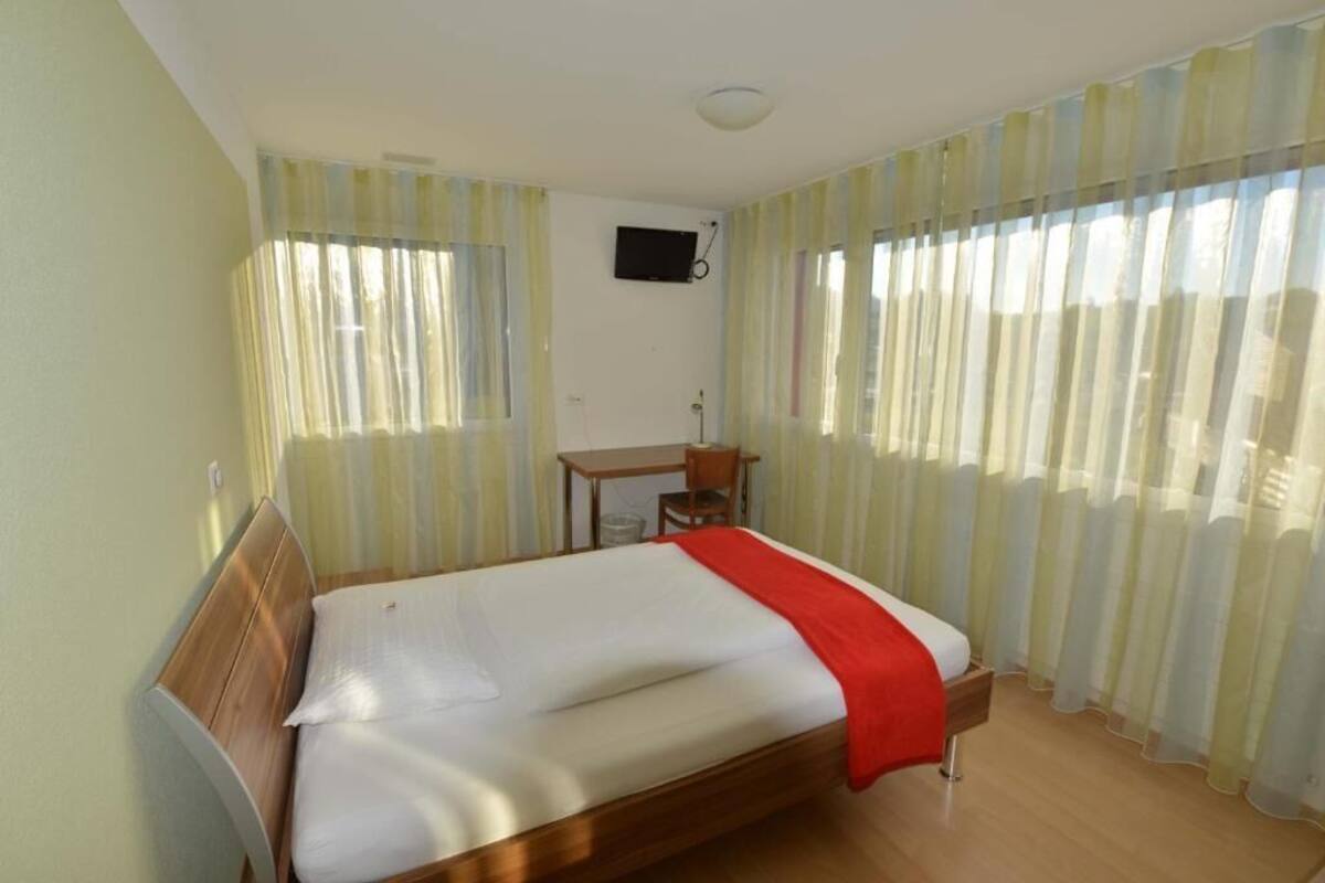 A room with a bed, a desk, and a chair.