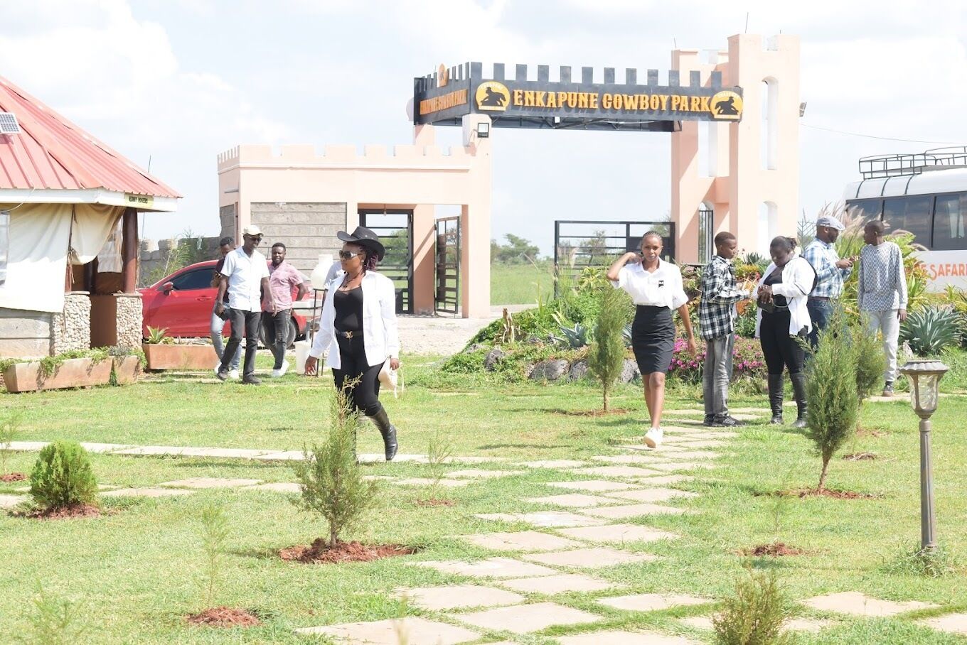 A paved pathway leading to a building with a sign reading 'ENKAPUNE COWBOY PARK'.