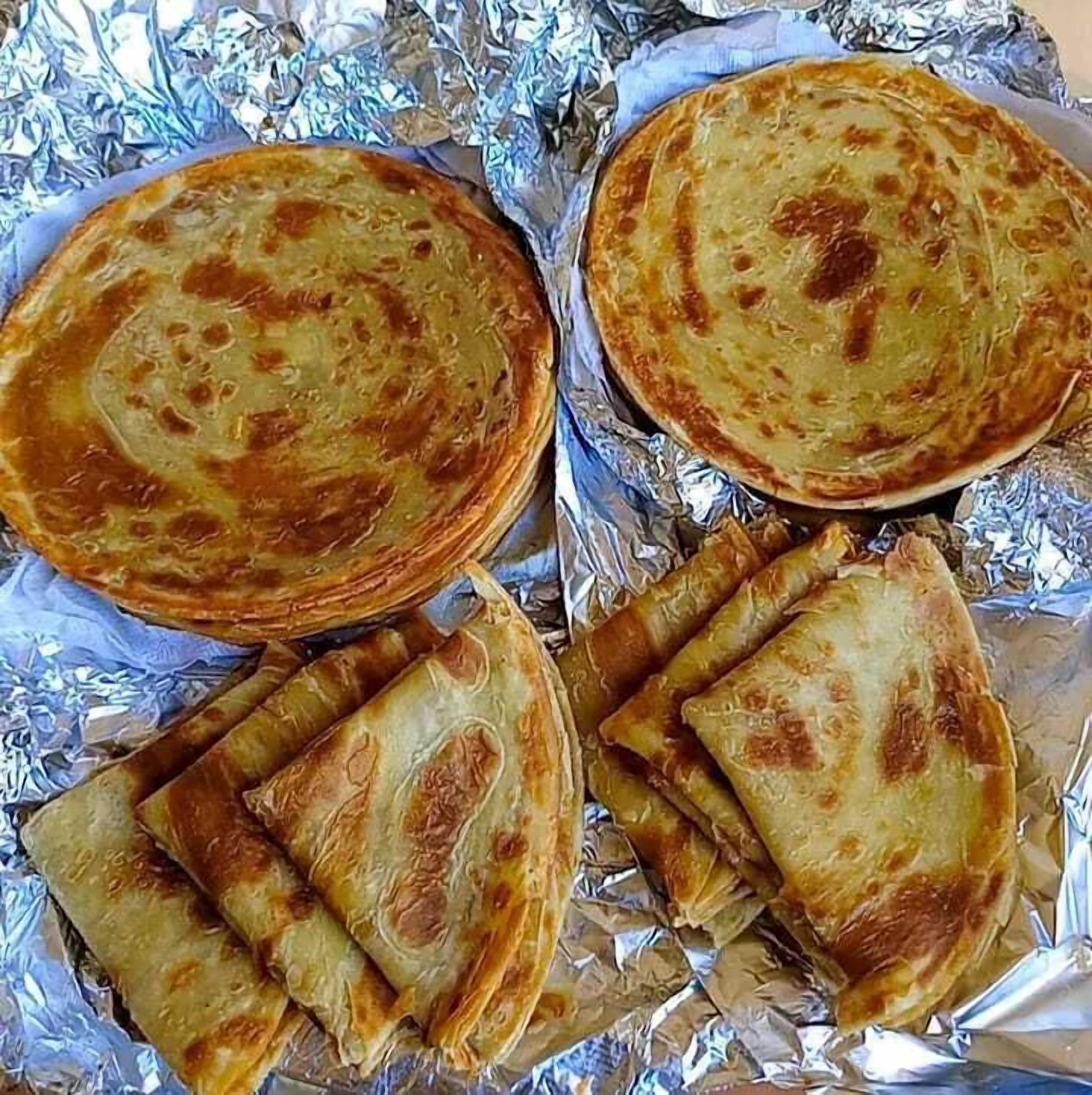 A variety of flatbreads on aluminum foil.