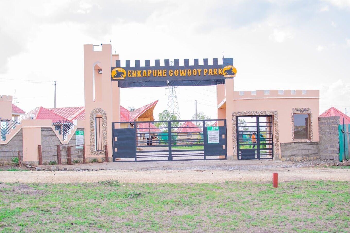 A gated entrance to Enkapune Cowboy Park with a sign above the gate.